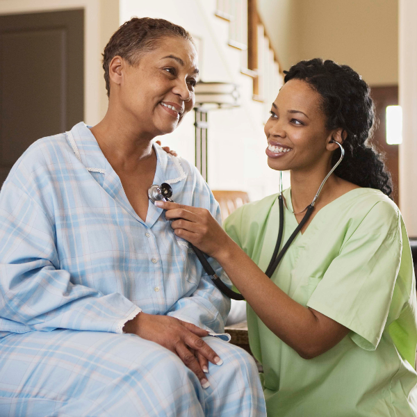 A nurse is checking the heartbeat of an older woman.