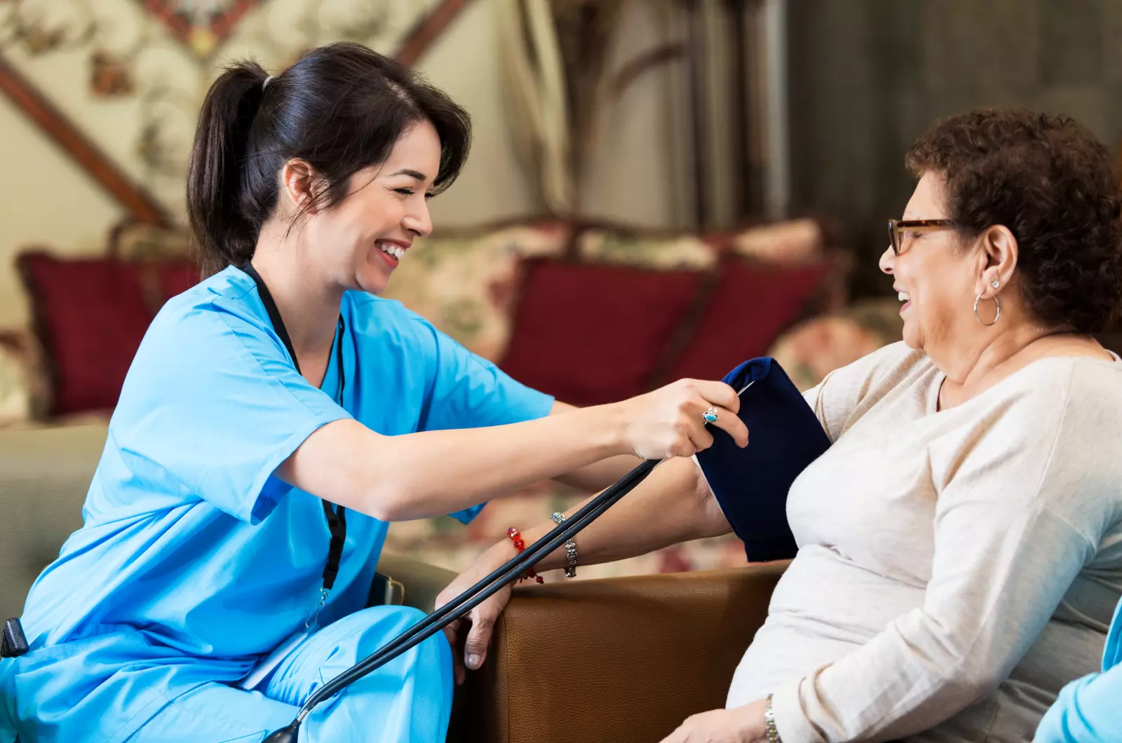 A nurse is helping an elderly woman with her medical equipment.