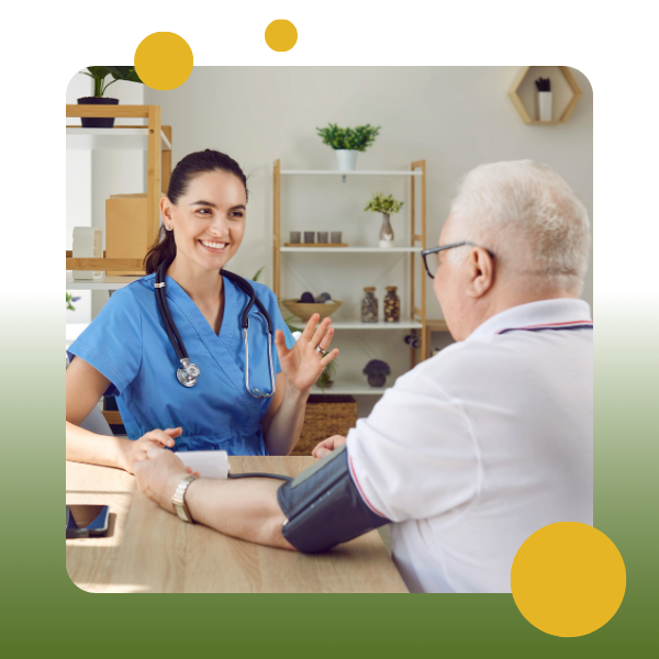 A nurse and an older man are sitting at a table.